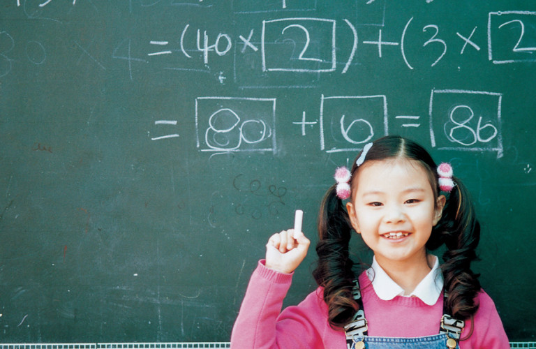 Student at a chalk board understanding math