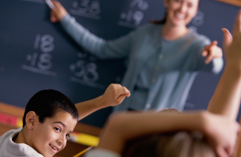 Young boy raising his hand in match class